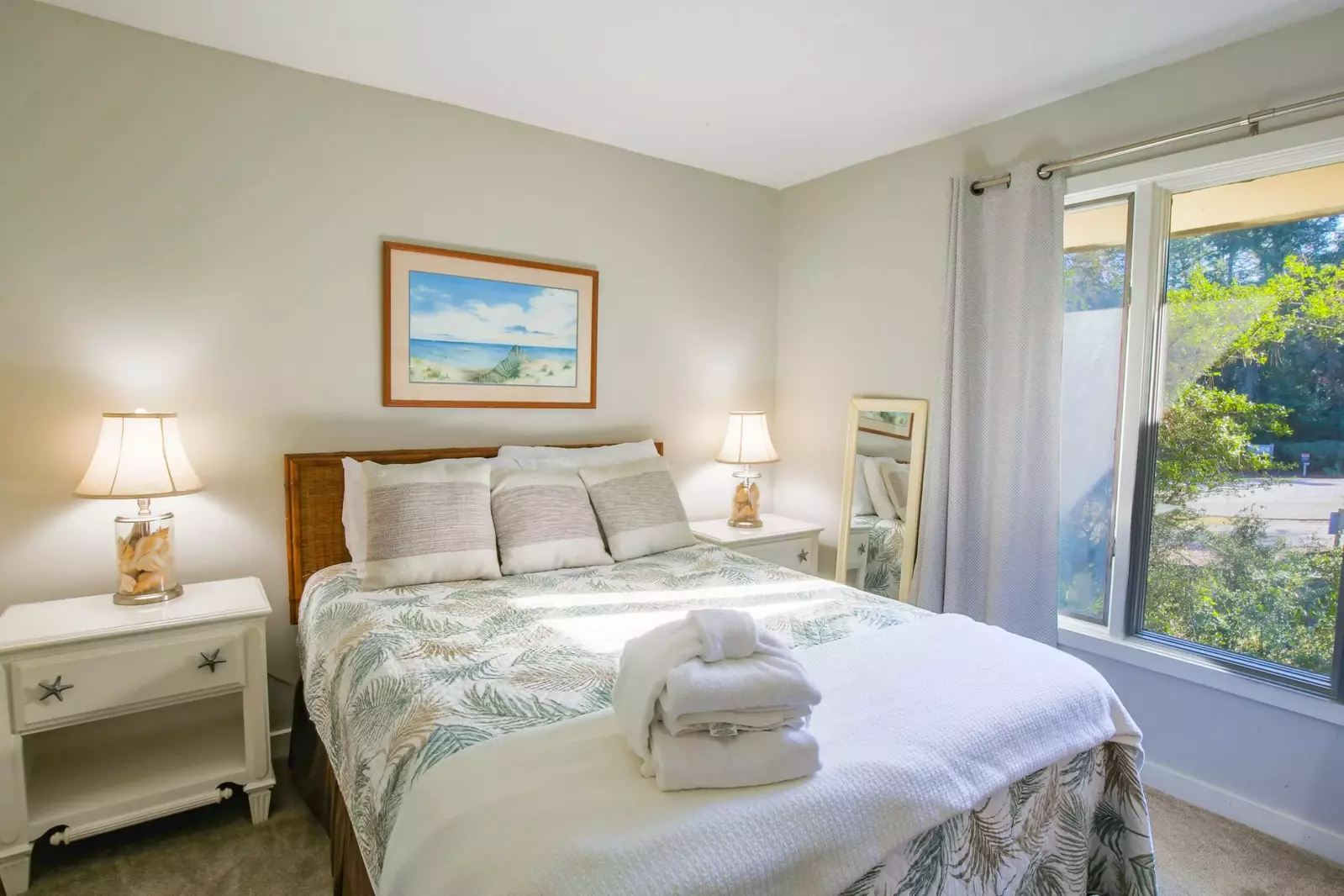 This guest bedroom features a queen bed, dresser and nightstands with lamps.