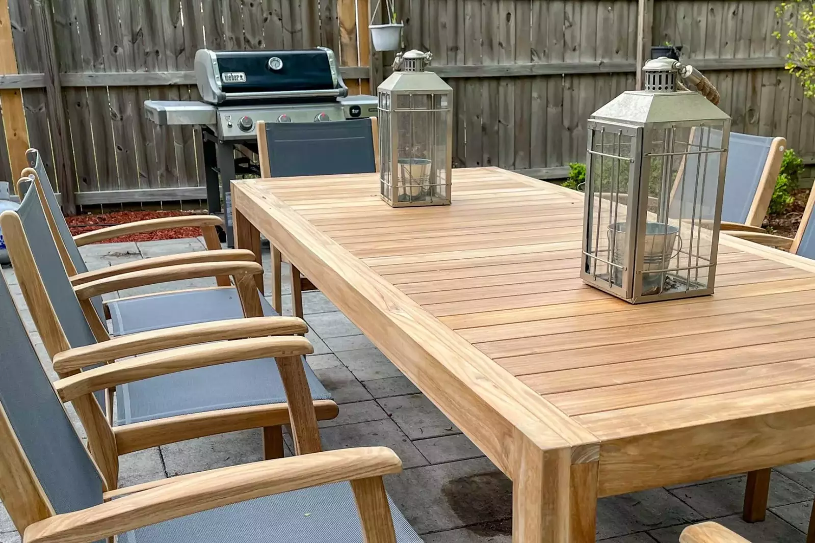 The backyard of the home features a paved patio, propane BBQ grill and dining table and chairs