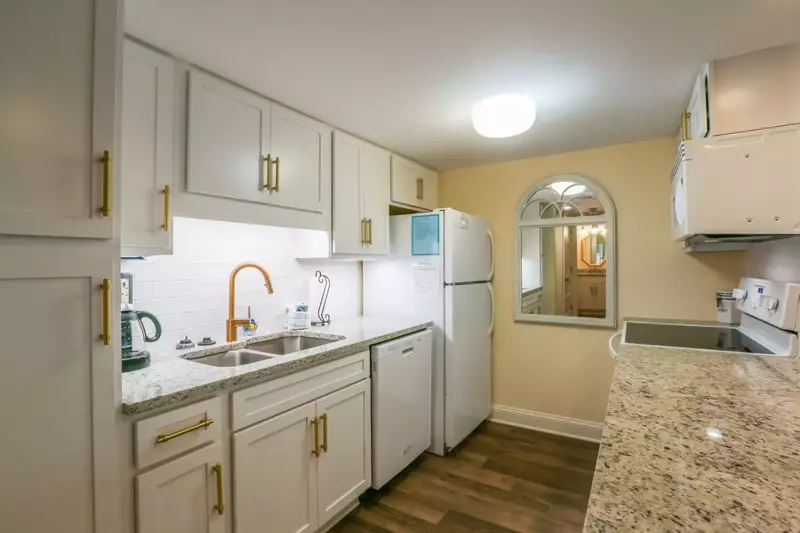 This gorgeous kitchen features white cabinetry, granite countertops and new flooring.