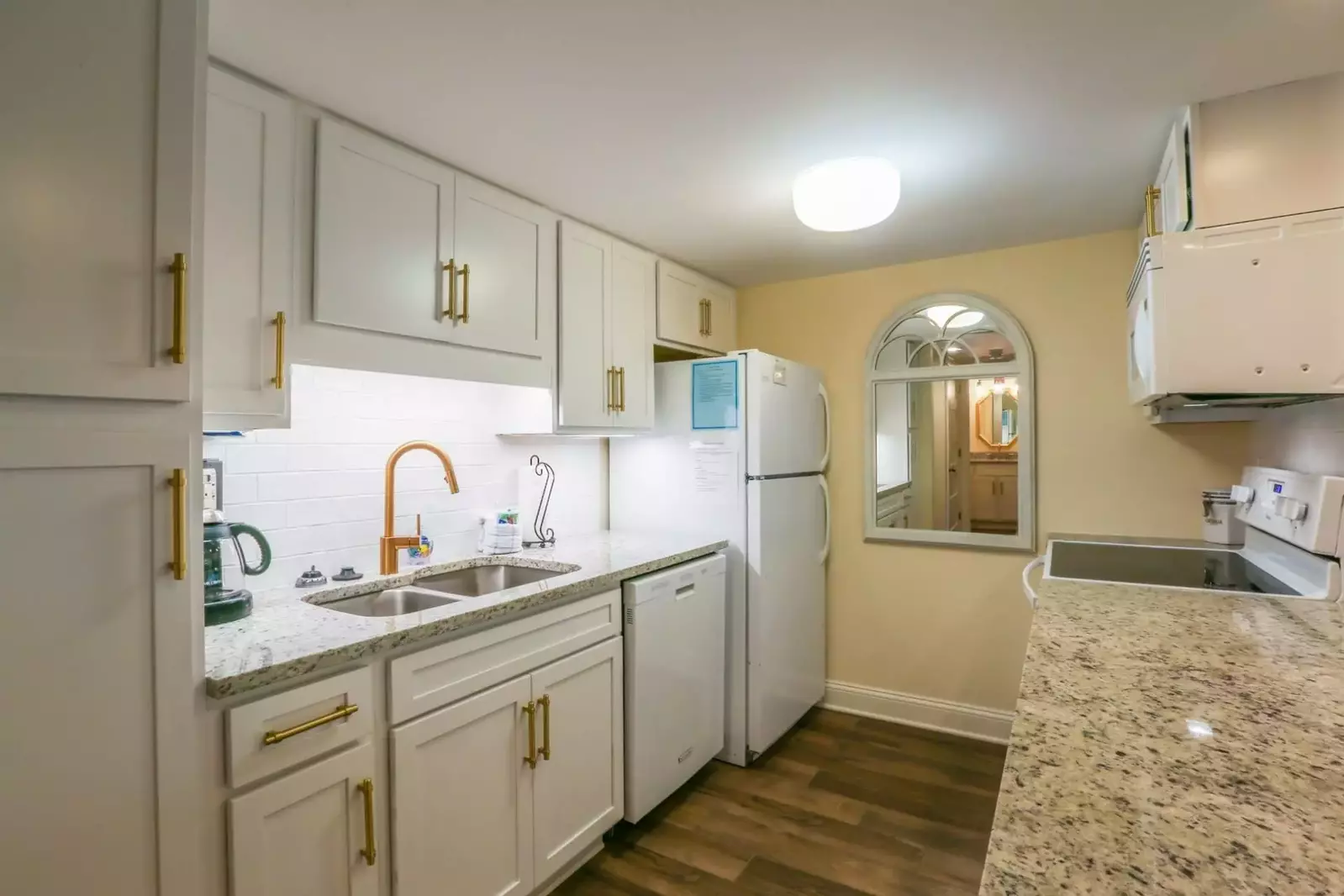 This gorgeous kitchen features white cabinetry, granite countertops and new flooring.