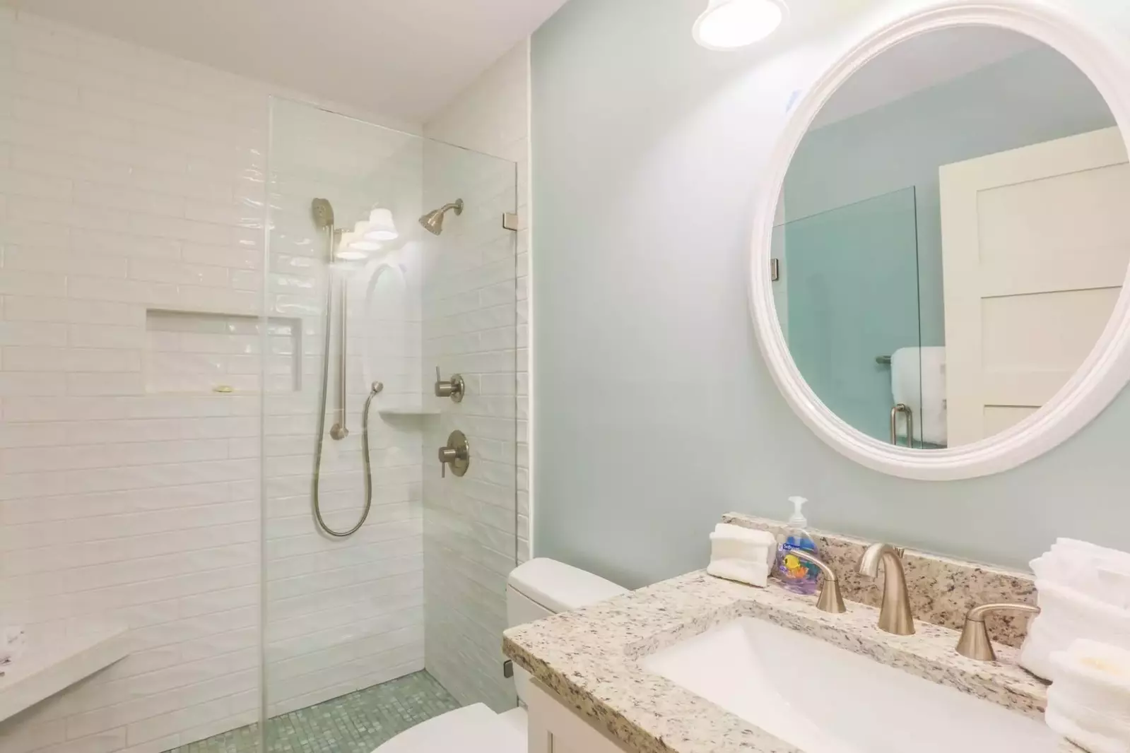The en suite bath for the master bedroom has a newly tiled, walk-in shower with multiple shower heads.