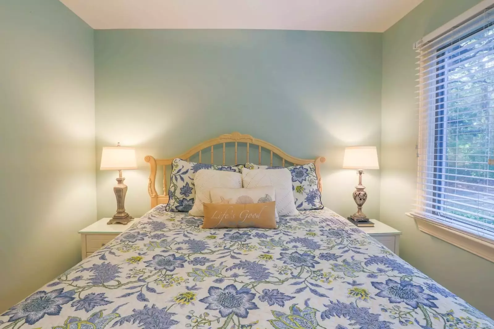 The guest bedroom has a queen bed and night stands with reading lamps.