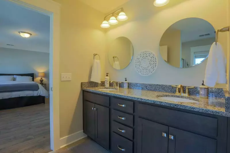 The master bathroom features a his & her double-sink vanity, walk-in shower, tub and water closet.