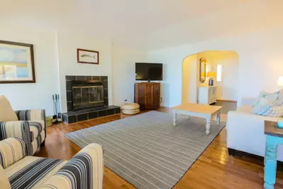 The family room features a large screen TV with Roku, comfortable seating area and hardwood floors.