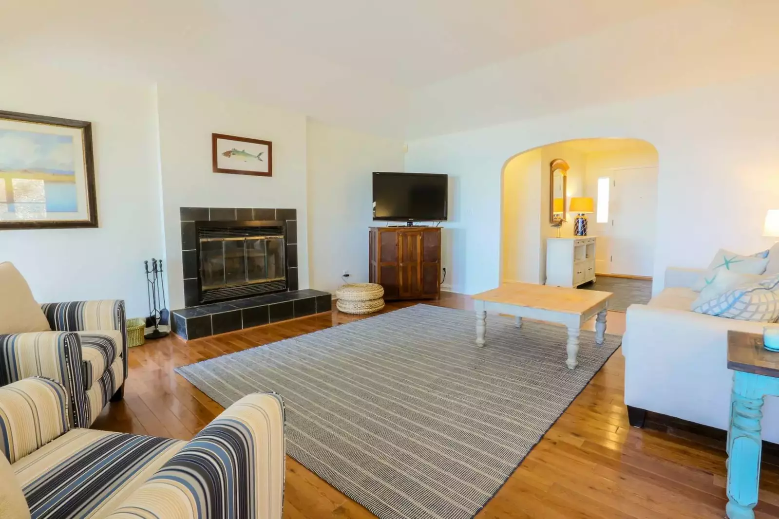 The family room features a large screen TV with Roku, comfortable seating area and hardwood floors.