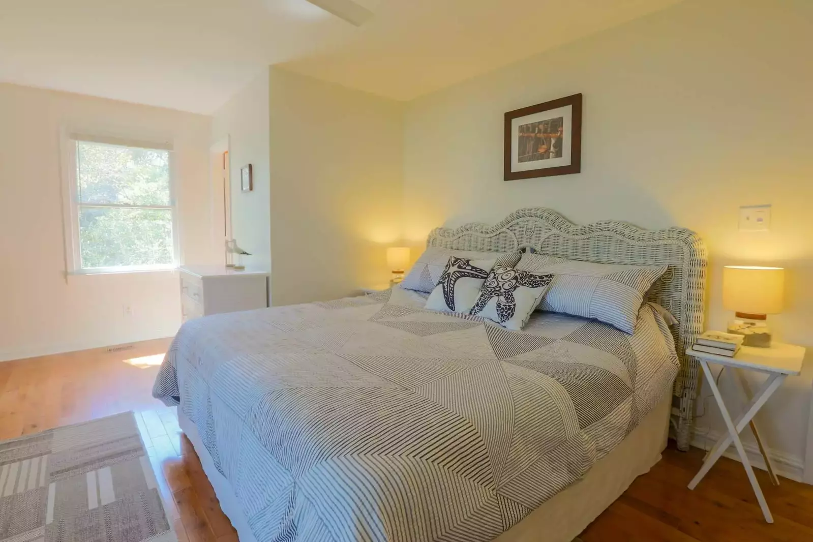 The master bedroom has a king bed, ceiling fan, dresser and night stands with reading lights.