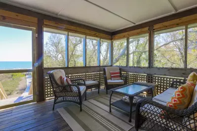 This screened porch sitting area with ocean views is located off the master bedroom.