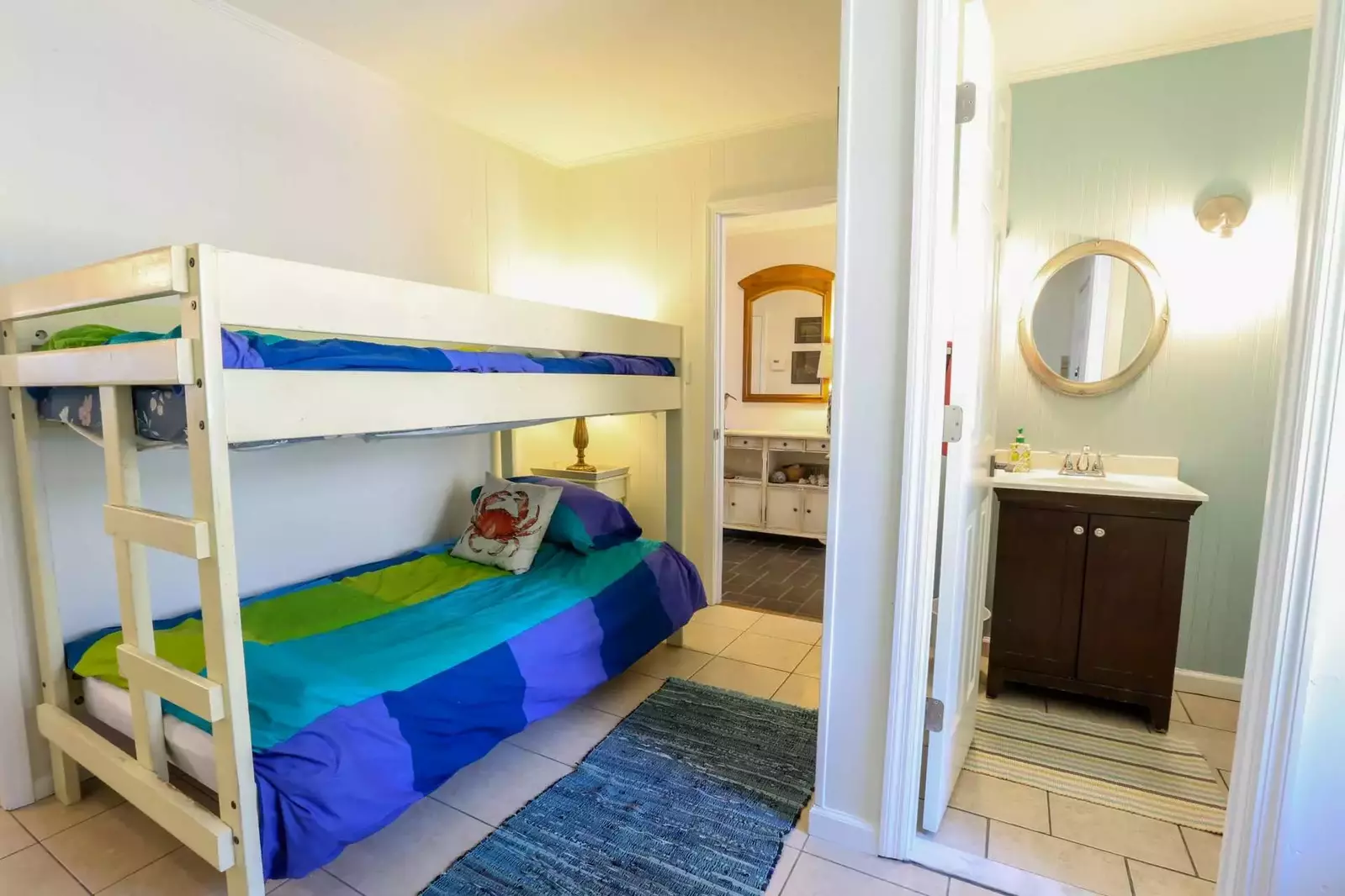 Between the kitchen and foyer is a guest bedroom with a bunk bed and en suite half bathroom.