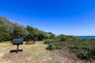 There is a charcoal grill and picnic table available for guests in the backyard.
