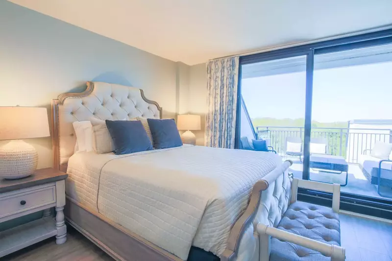 The guest suite on the upper level features a queen bed and sliding door access to the private roof deck.