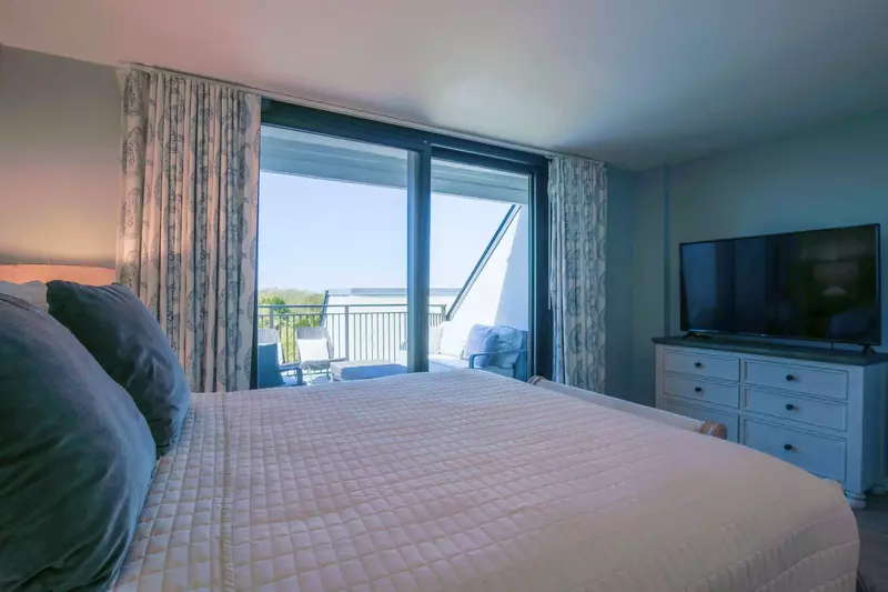 This guest bedroom also has a dresser and a smart TV.