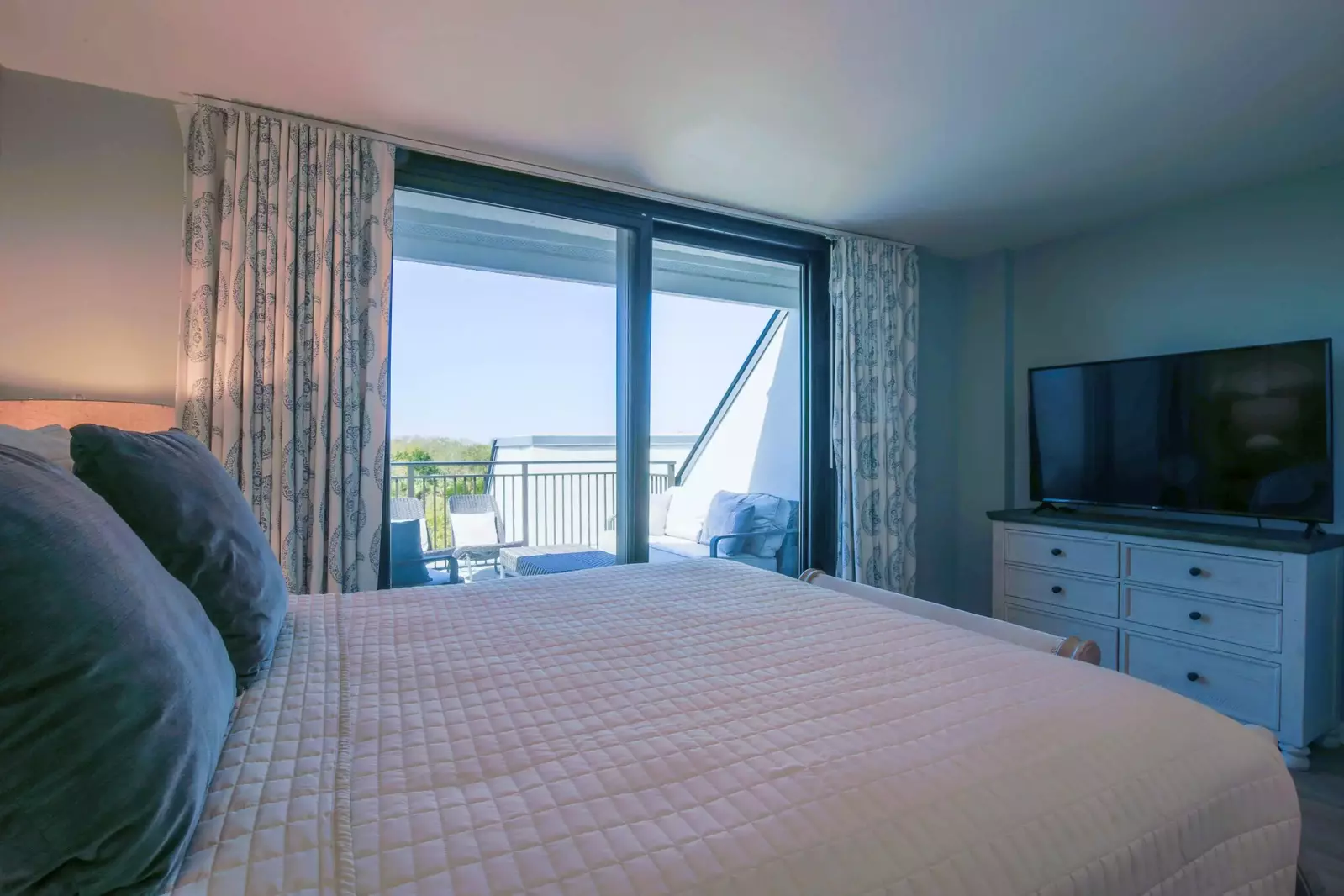 This guest bedroom also has a dresser and a smart TV.