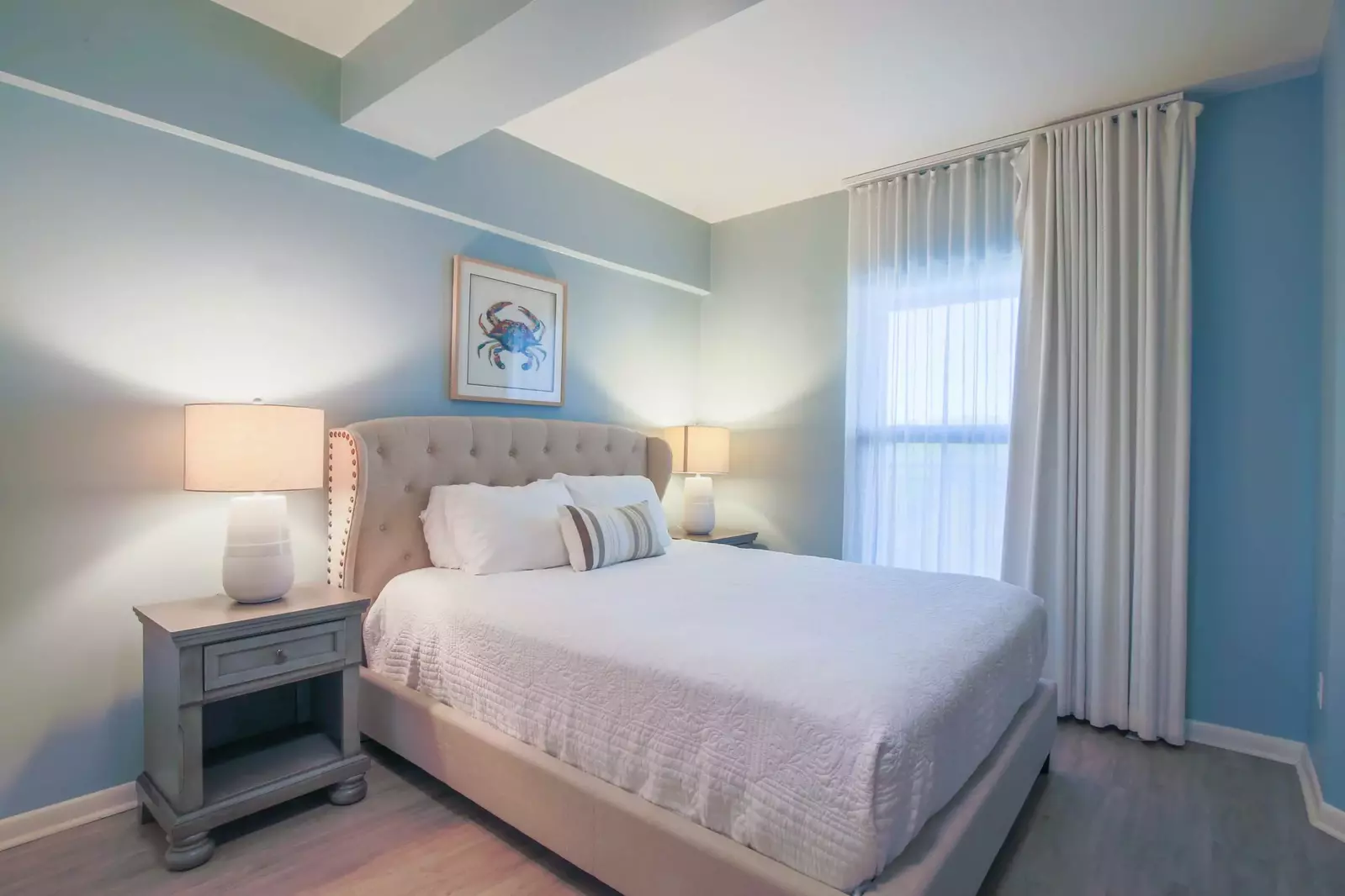 This lower level guest bedroom features a queen bed and hardwood floors.