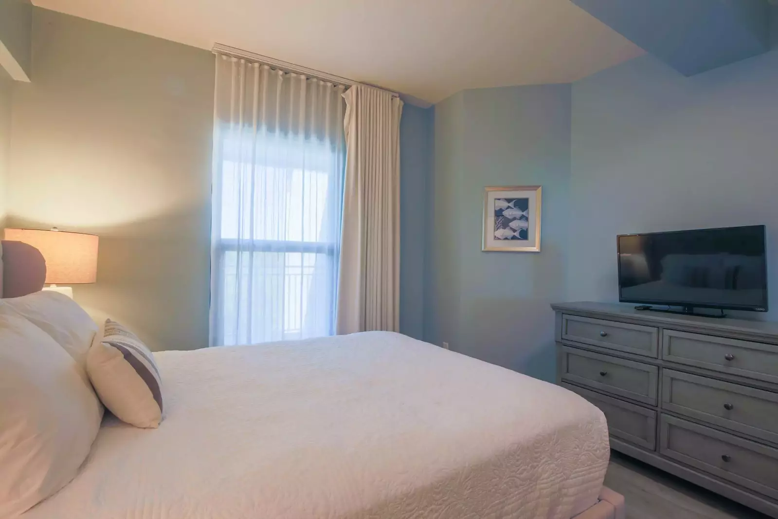 This lower level guest bedroom also features a dresser and smart TV.