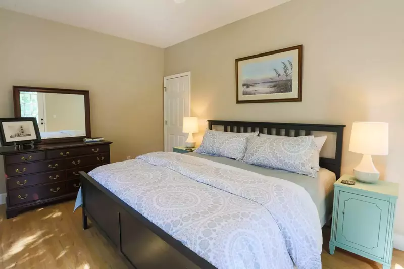 The master bedroom features a king bed, dresser, nightstands with reading lamps and a ceiling fan.