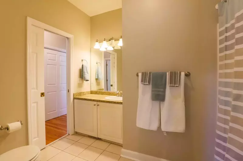 The bathroom features tile floors, a shower/tub combo and a vanity with countertop & cabinet storage areas.