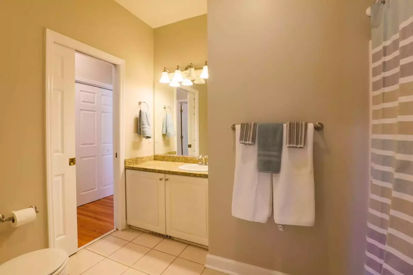 The bathroom features tile floors, a shower/tub combo and a vanity with countertop & cabinet storage areas.