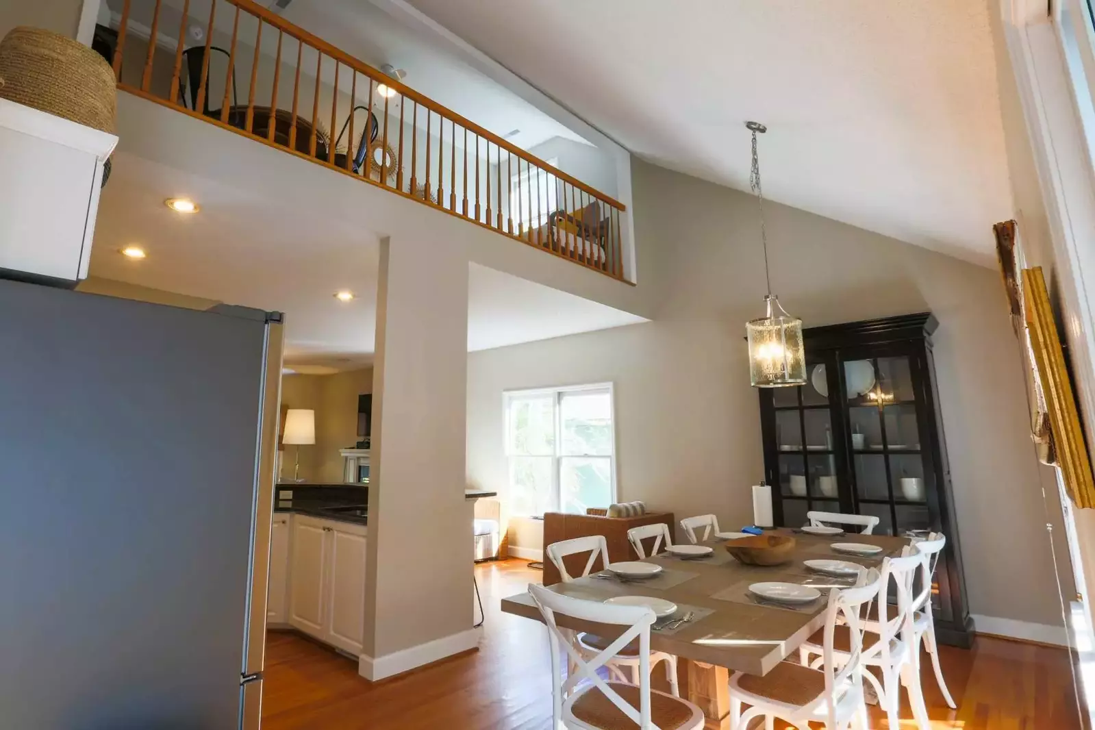 The second floor balcony overlooks the first floor dining room area.