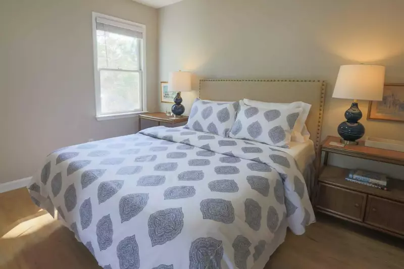 This lovely guest bedroom features a queen bed and nightstands with reading lamps.