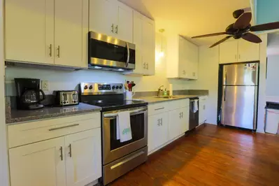 The newly renovated kitchen features new cabinets, new countertops and new lighting.