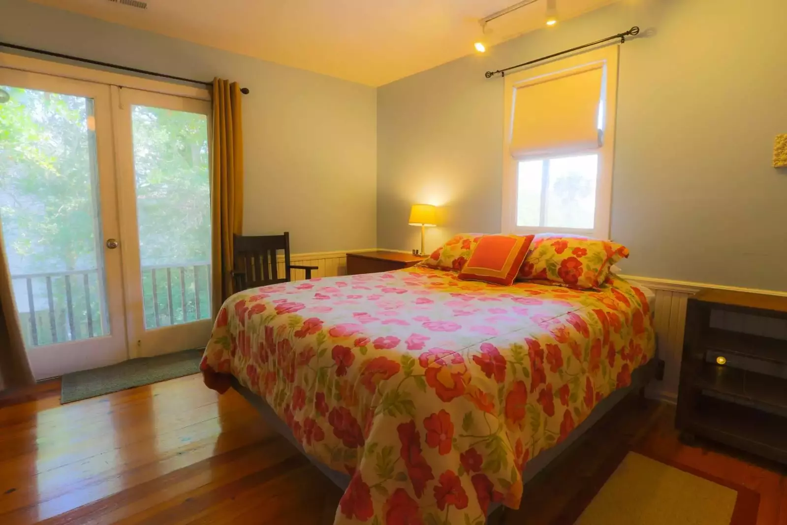 The front bedroom also features nightstands, hardwood floors and French door access to a screened-in porch.