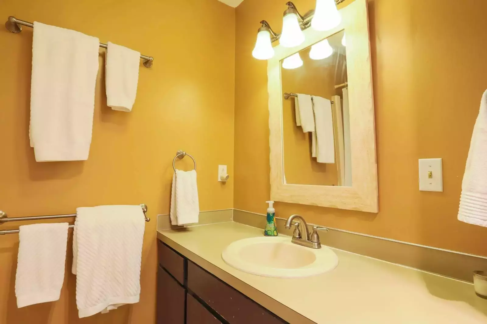 This full bathroom features a combined shower/tub, large vanity and ample storage area.