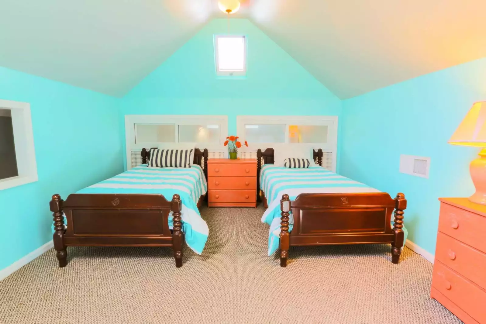The loft bedroom has 3 twin sized beds, 2 dressers and ceiling fans.
