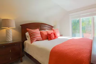 The master bedroom has a king size bed and night stands with reading lamps.