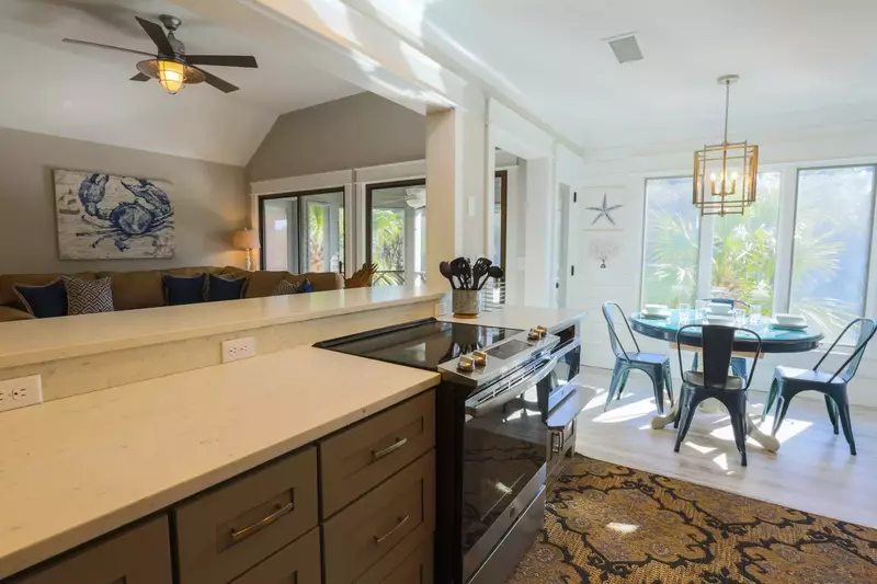 The open wall between the kitchen and living room allow guests to engage with one another throughout this open space.