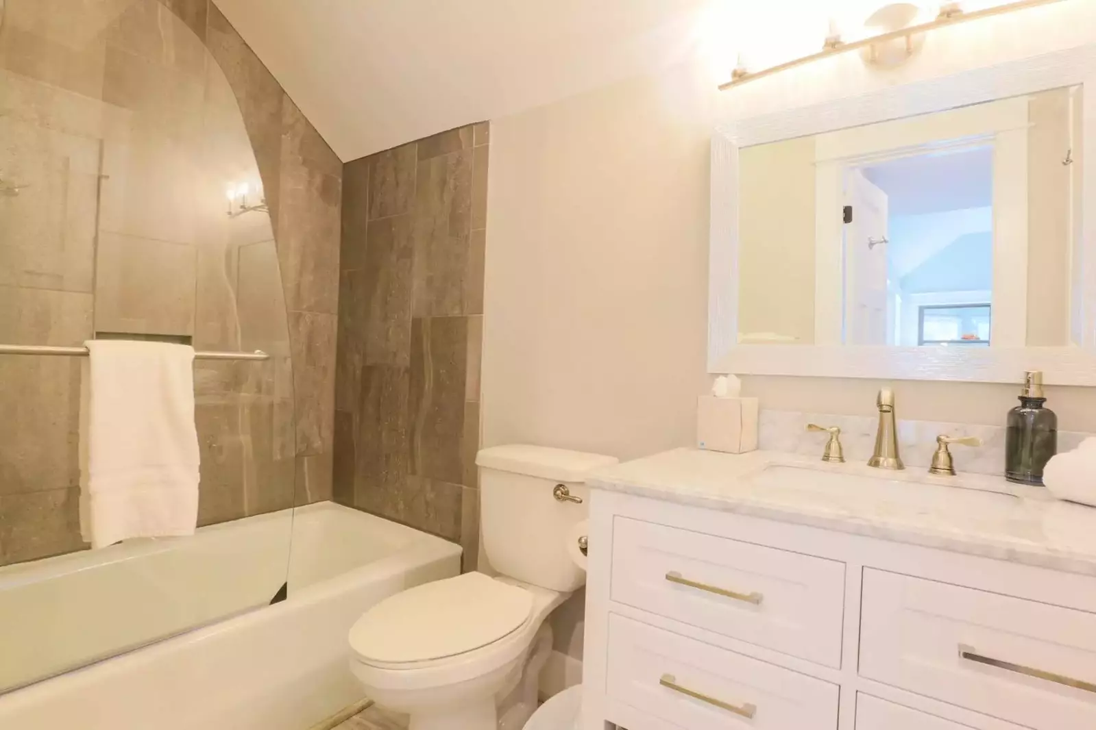 The guest bathroom has a large vanity and a tiled tub/shower combo.
