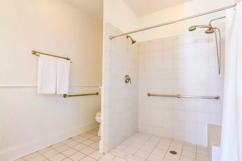 This handicap accessible bathroom has a tiled, walk-in shower.