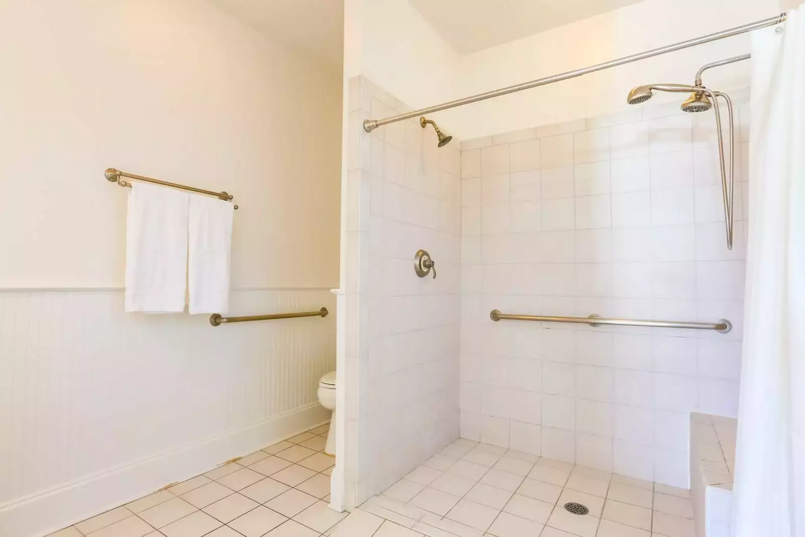 This handicap accessible bathroom has a tiled, walk-in shower.
