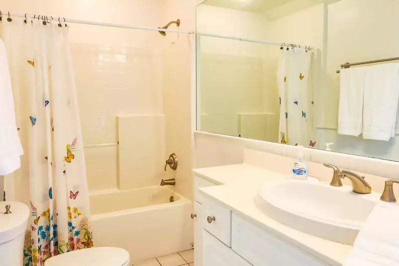 This en suite bathroom features a tiled shower/tub combo and a vanity with lots of storage room for your personal items.