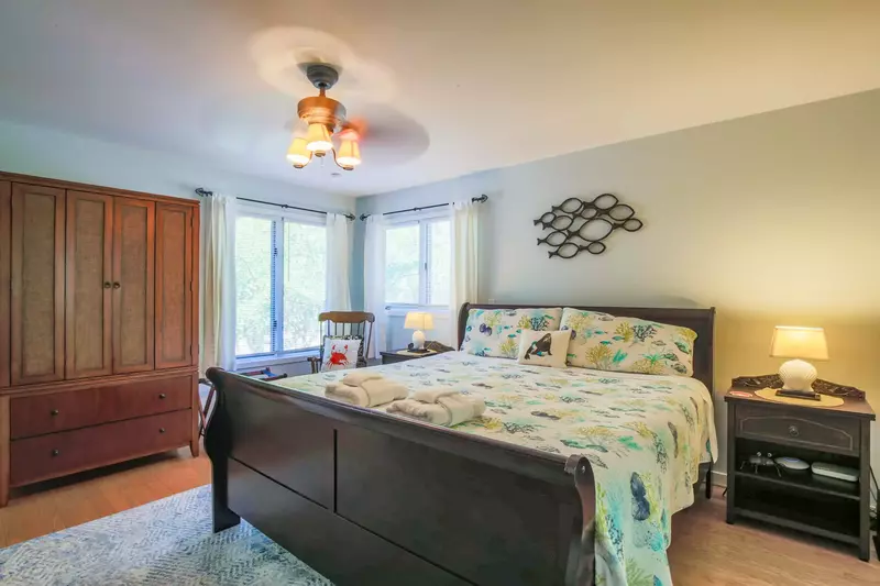 The master suite also has an armoire, ceiling fan and chair.