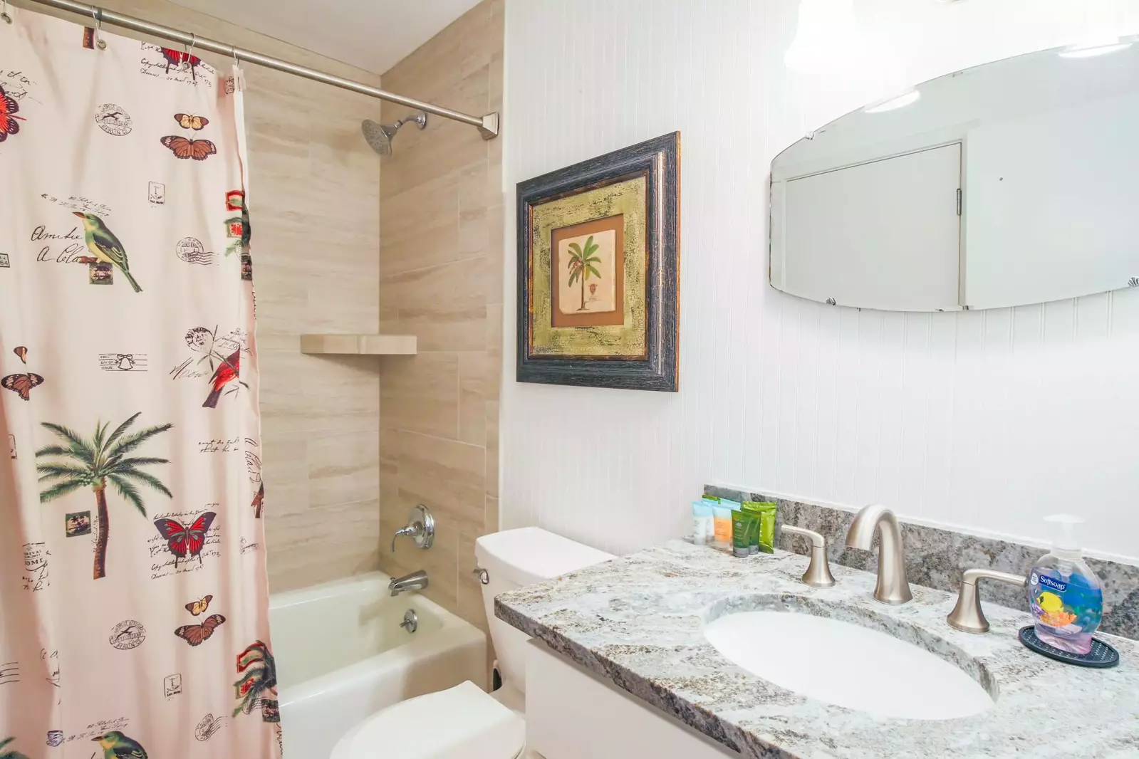 This bathroom features a tiled shower/tub combo and spacious vanity.