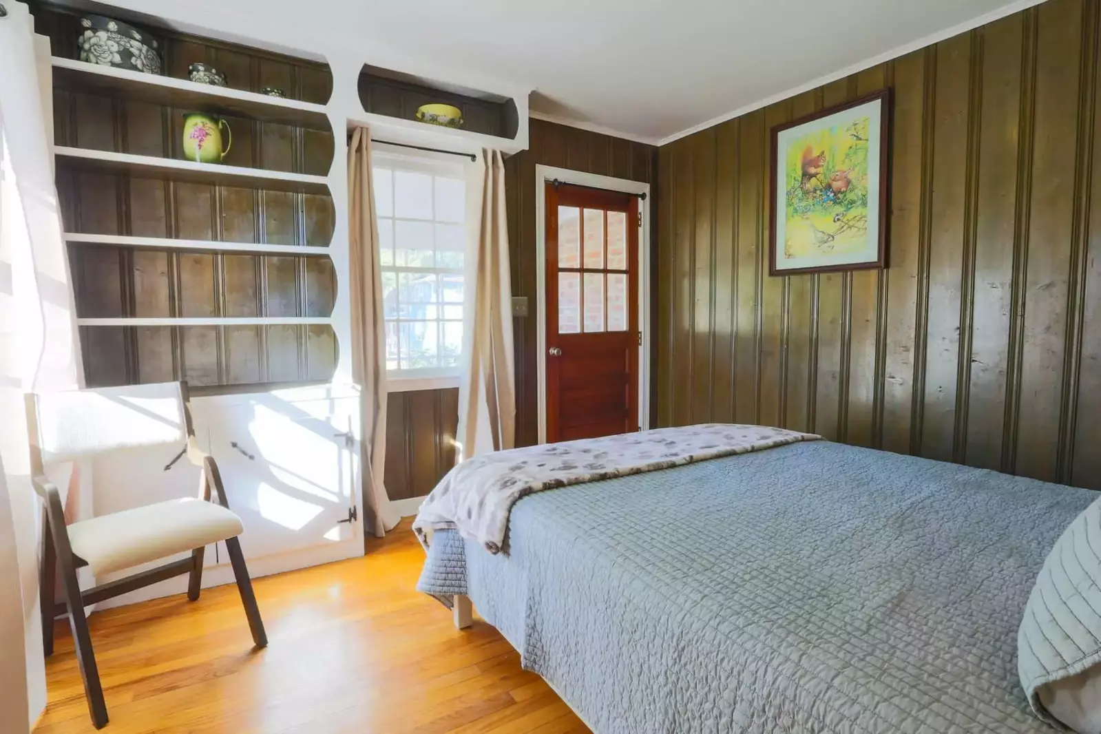 This beautiful room also has wood paneled walls, a built-in bookcase and access to a sunroom.