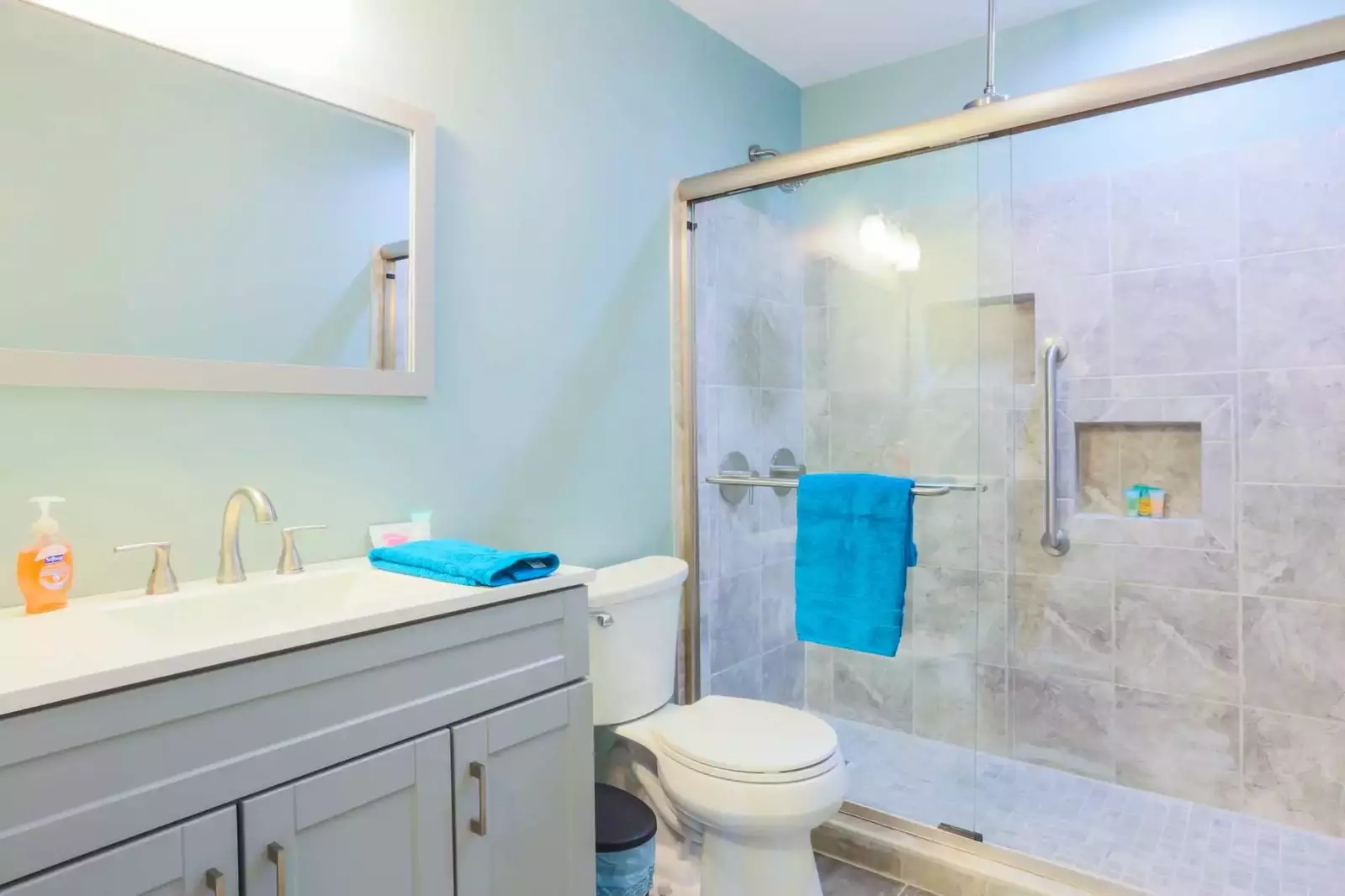 This full bathroom near the dining room features a walk-in, tiled shower.