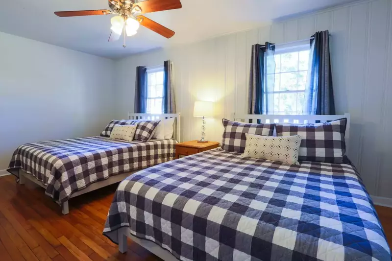 This bedroom features two queen sized beds, a ceiling fan and excellent natural light.