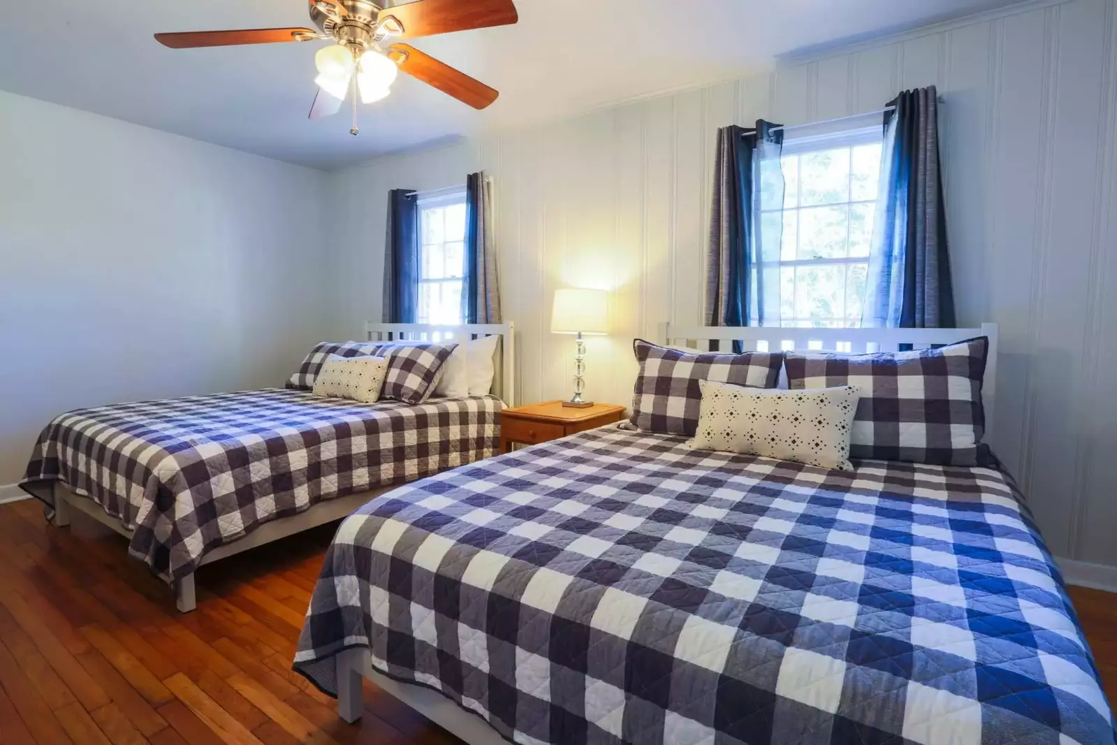 This bedroom features two queen sized beds, a ceiling fan and excellent natural light.