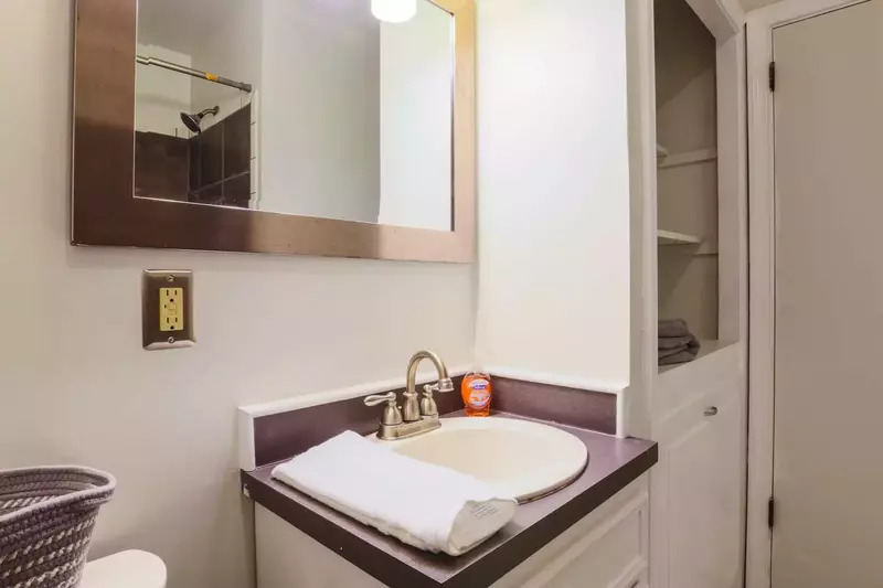 This bathroom in the hallway near the three bedrooms has built-in shelves for storage.