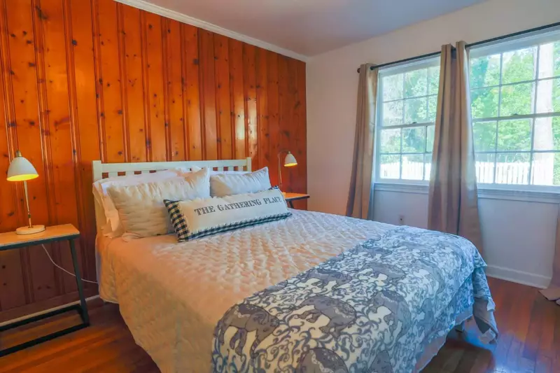 This inviting bedroom overlooks the home's backyard.