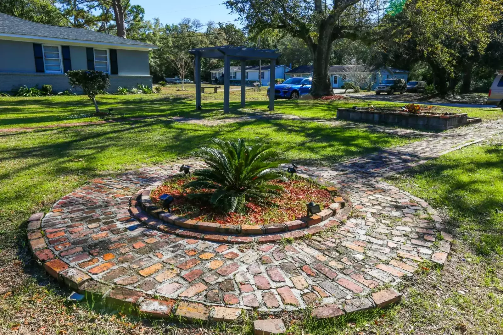 The front yard has outdoor lighting installed to illuminate the walkways at night.