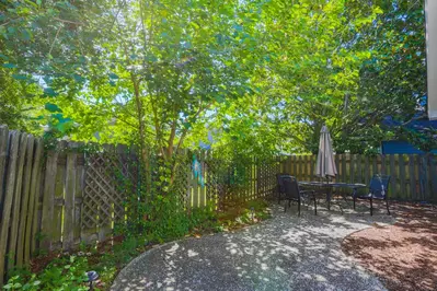 The home features a private, fenced backyard with an outdoor dining table & chairs.