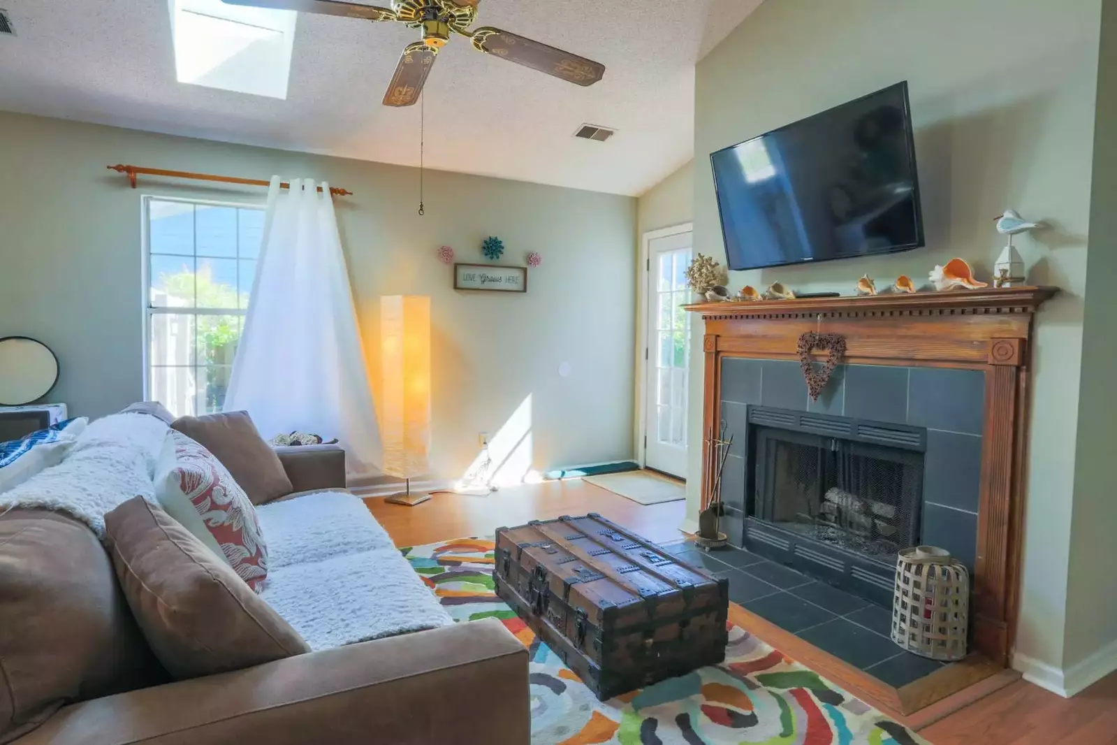 The door to the left of the fireplace and mounted TV in this photo leads to the backyard patio.