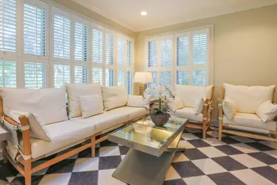 This cozy sunroom looks out over the park-like setting behind the home.