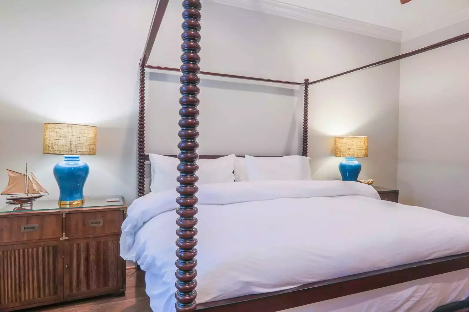 The king bed in the master suite is flanked by two nightstands with blue reading lamps.