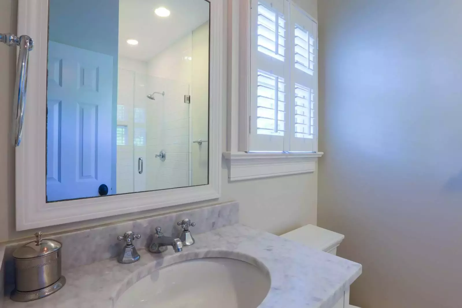 This en suite bathroom features a tiled walk-in shower and vanity.