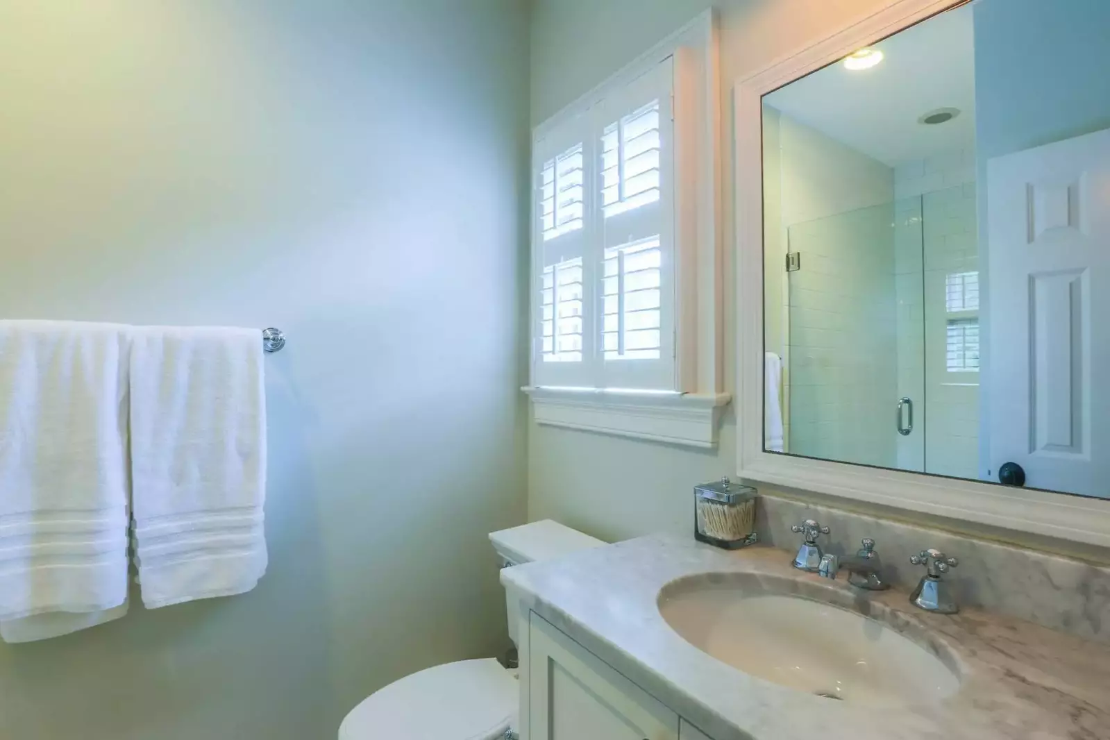 The en suite bathroom features a tiled walk-in shower and marble top vanity.