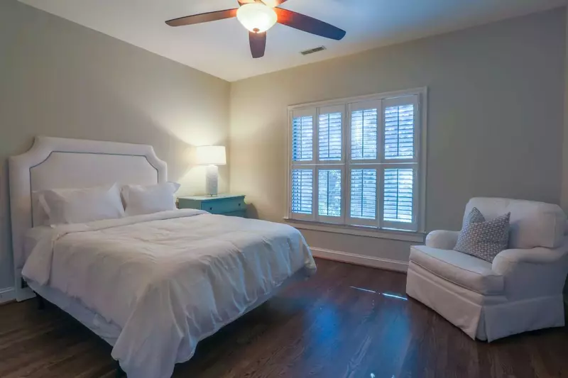 This guest bedroom has a queen bed and hardwood floors.