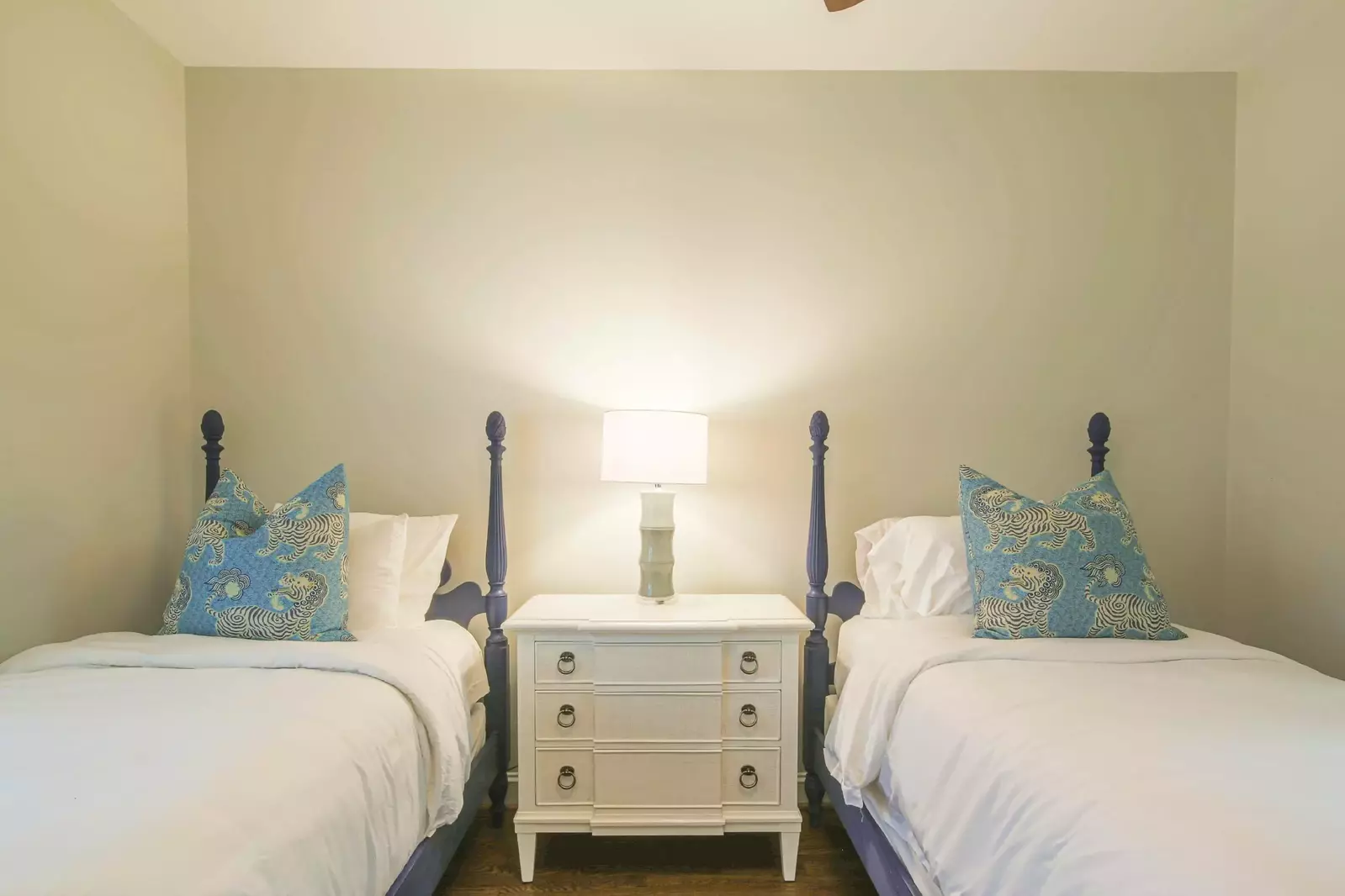 There is a nightstand with a reading lamp that separates the two twin beds.